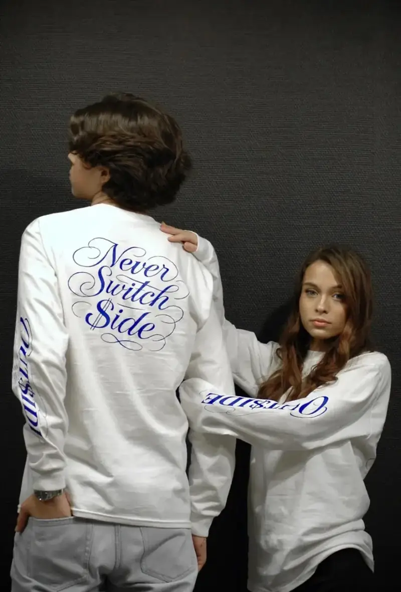 Duo portant le t-shirt manches longues blanc Never Switch $ide, studio fond gris