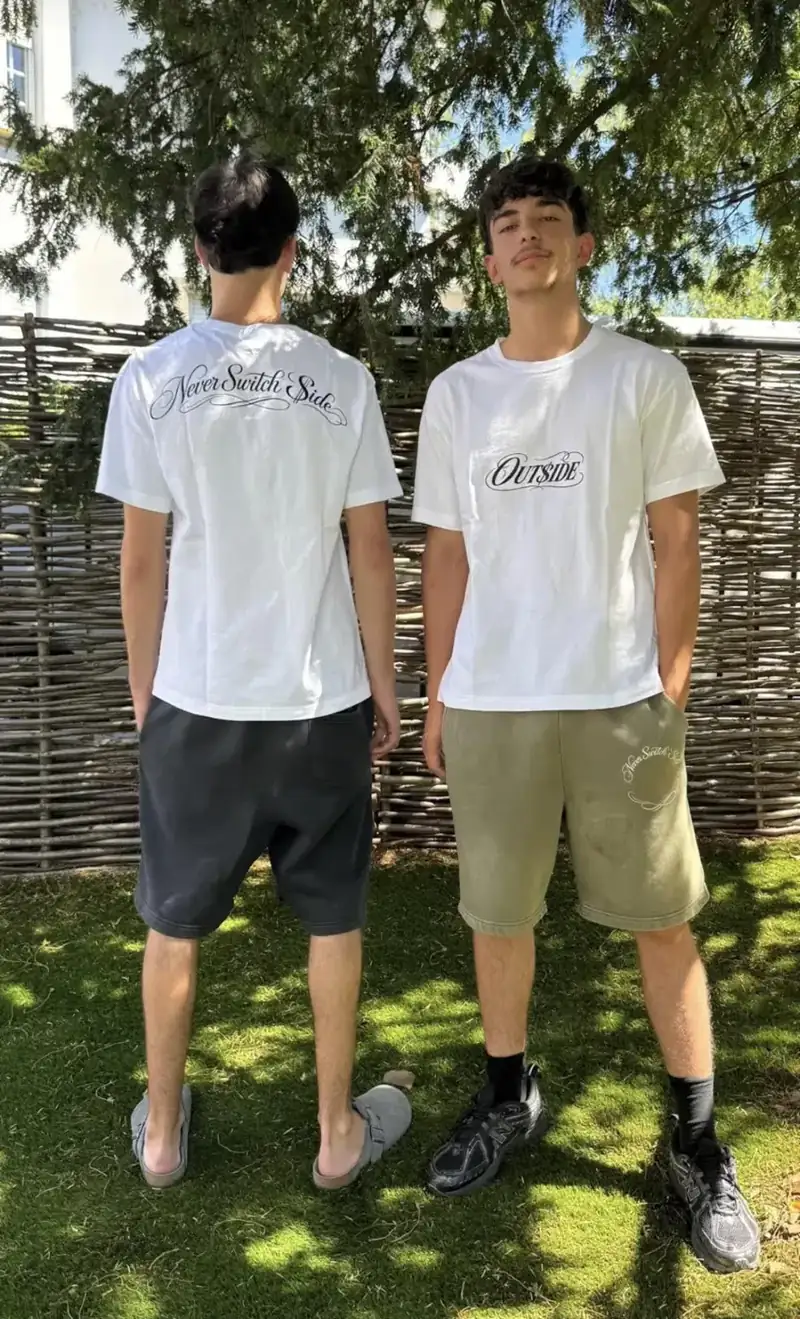 Duo en t-shirts blancs OUT$ide et shorts, en extérieur